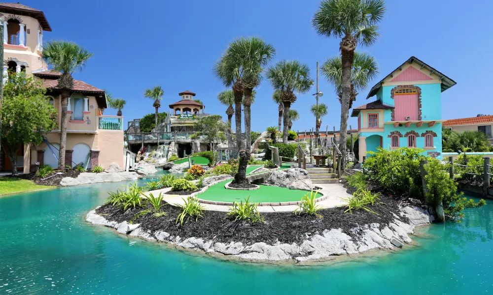 palm trees on a minigolf course surrounded by turquoise waters